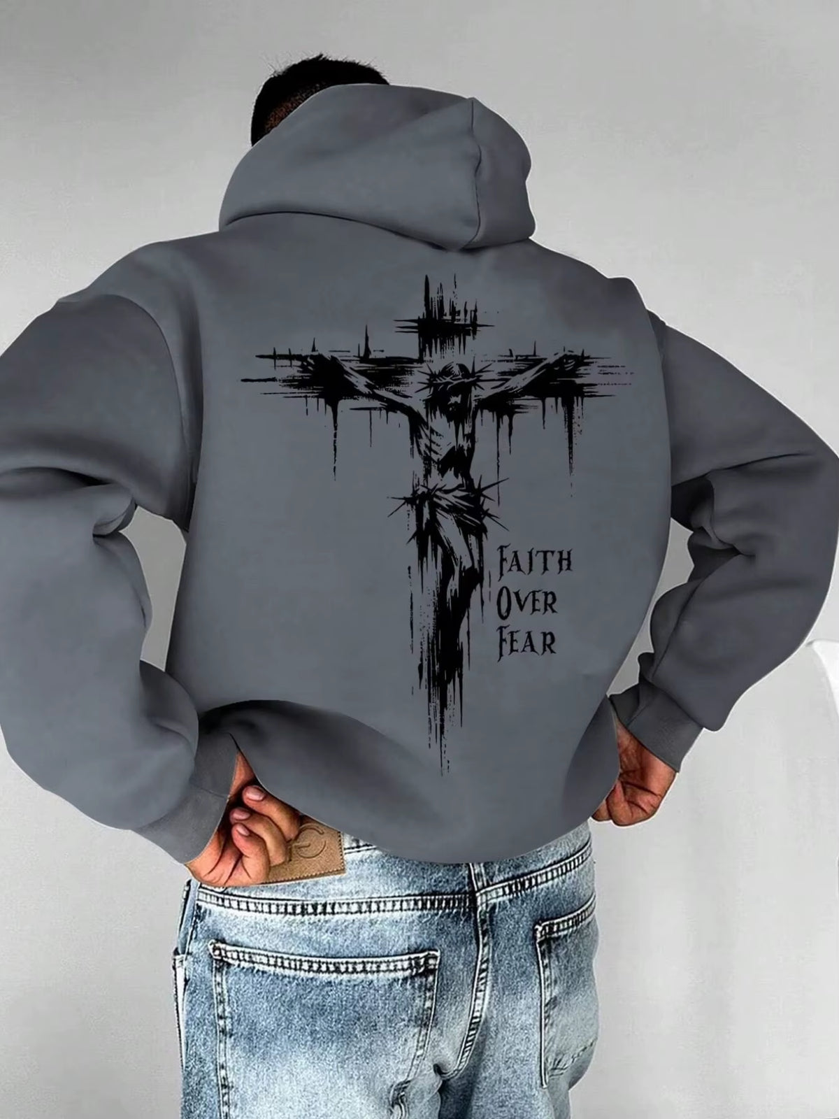 A Men'S Hoodie with the Words "Christian Faith Overcomes Fear" Printed on It Features a Cross-Shaped Design on the Back